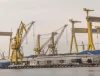 Macaralele Șantierului Naval Mangalia oglindite în apă, într-o zi înnorată