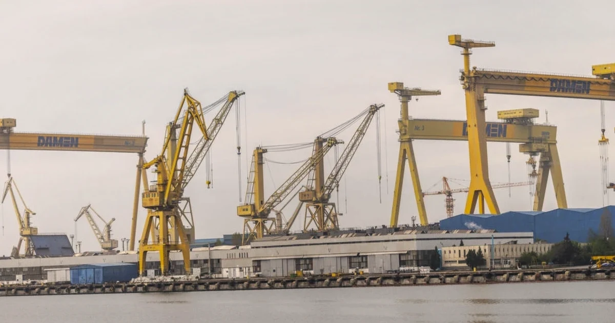 Macaralele Șantierului Naval Mangalia oglindite în apă, într-o zi înnorată